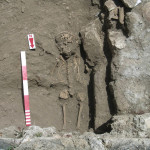 Figure 61. Grave (T026) containing a child buried with a lamp chain reused as a necklace (086). The skeleton 2201* is cut by the later castrum wall.